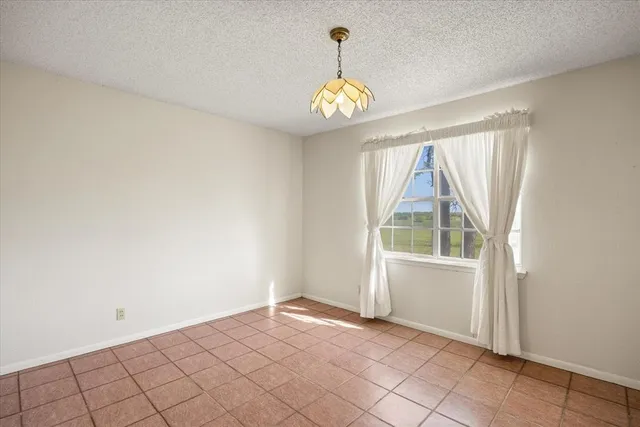 an empty room with windows and chandelier