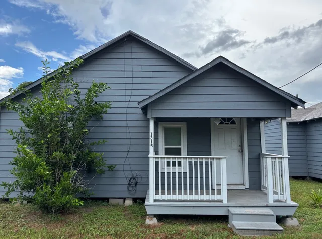 a view of a house with a small yard and wooden fence