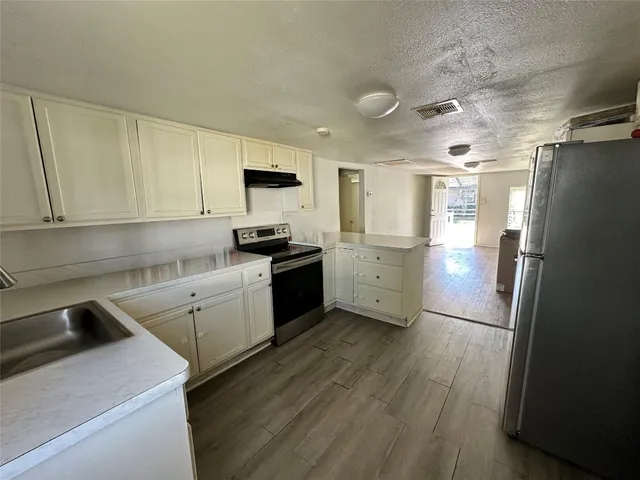 a kitchen with a refrigerator a sink and cabinets