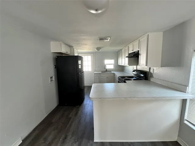 a kitchen with refrigerator and window