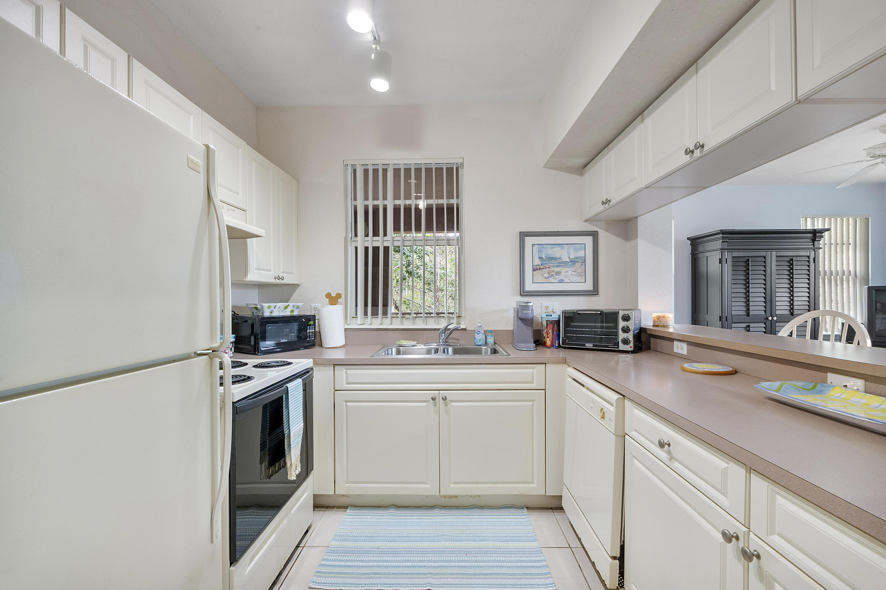 6592 West Sample Road, Unit 6592 Coral Springs, FL 33067 - Photo 12 of 42 a kitchen with a sink stove and cabinets