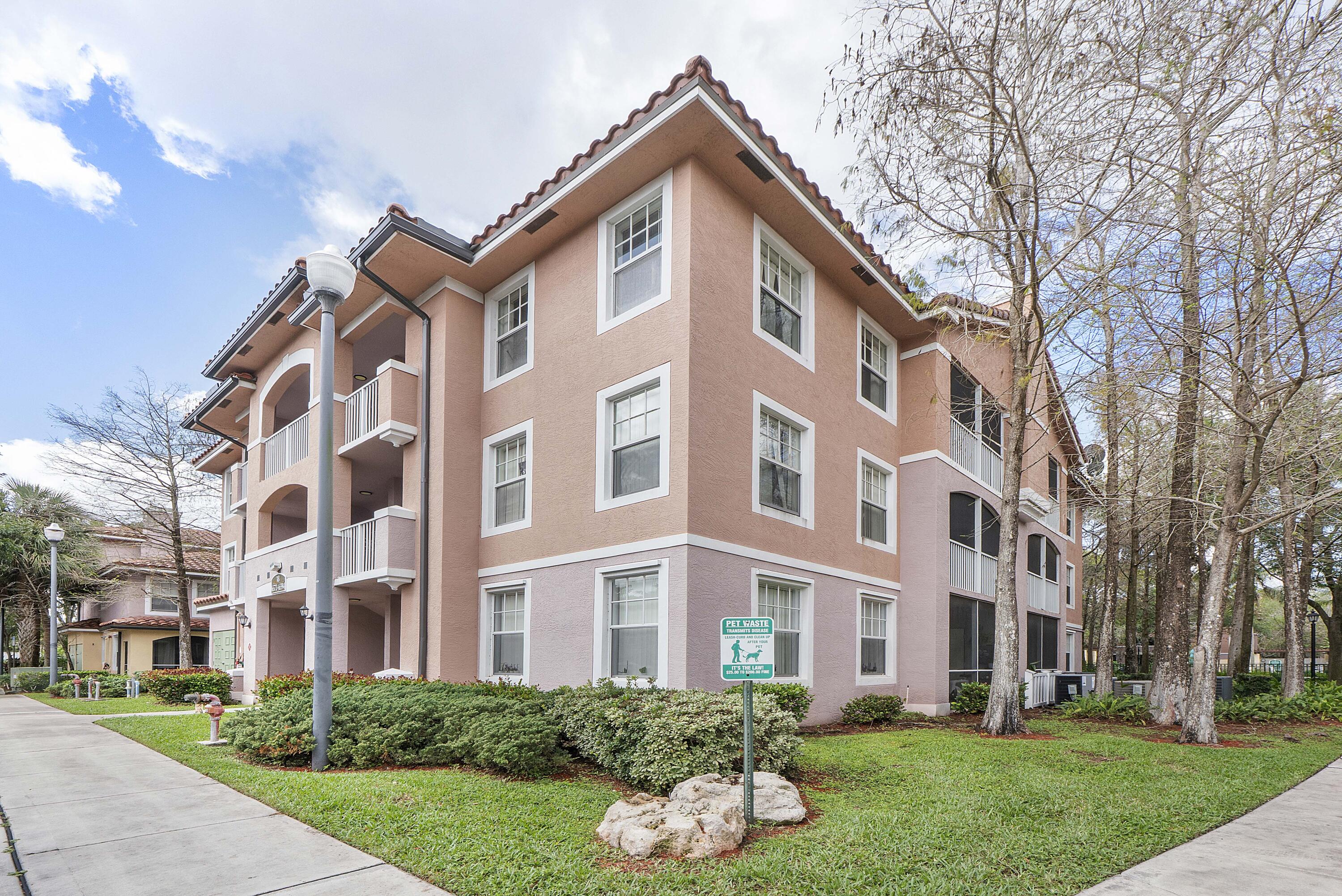 6592 West Sample Road, Unit 6592 Coral Springs, FL 33067 - Photo 2 of 42 front view of a building with a yard