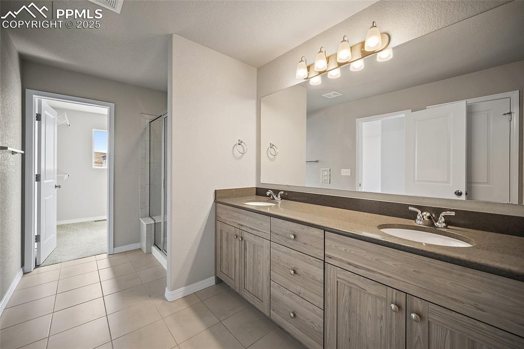 7768 Bone Crk Road Colorado Springs, CO 80924 - Photo 20 of 25 a bathroom with a sink double vanity and a mirror