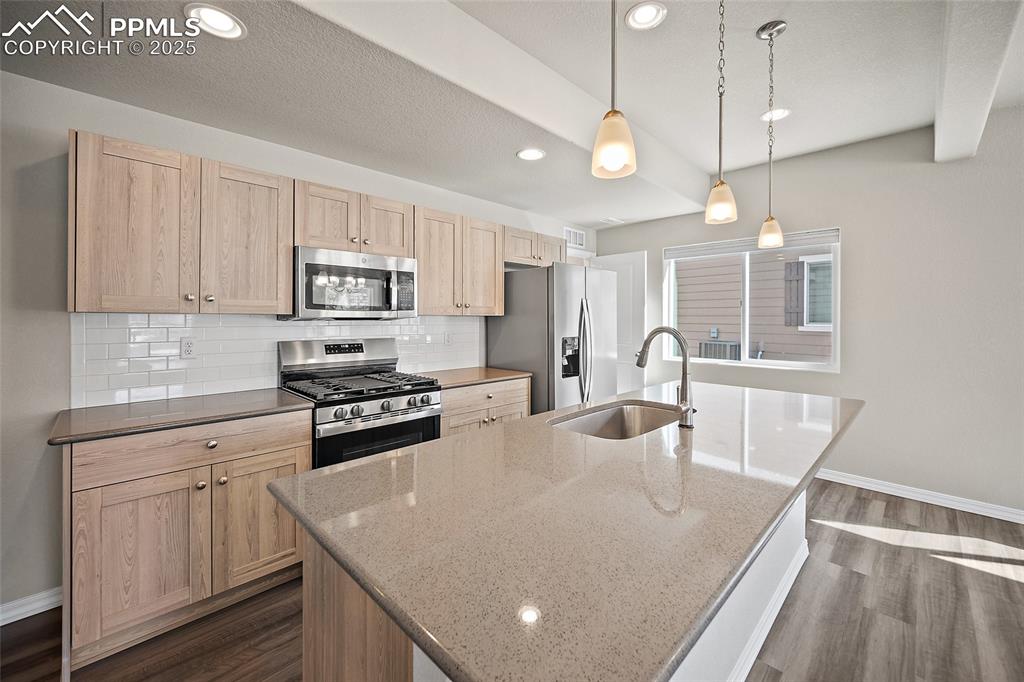 7768 Bone Crk Road Colorado Springs, CO 80924 - Photo 6 of 25 a kitchen with stainless steel appliances granite countertop a sink a stove and a refrigerator