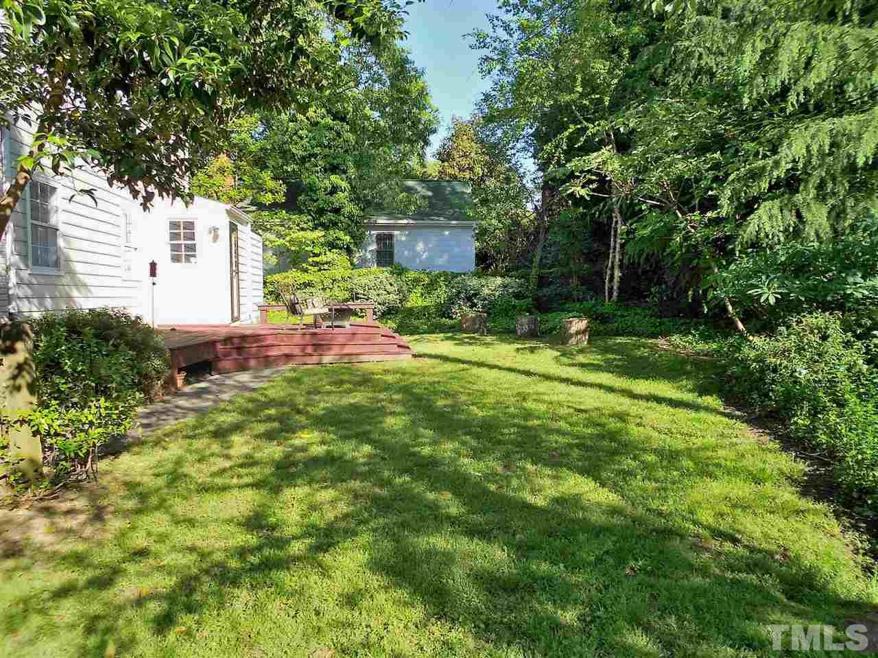 3307 Hall Place Raleigh, NC 27607 - Photo 19 of 24 a backyard of a house with table and chairs plants and large tree