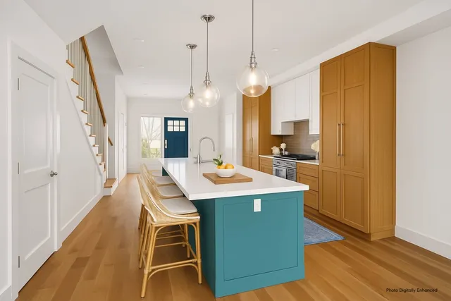 a room with kitchen island a wooden floor and a sink