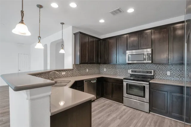 a kitchen with stainless steel appliances granite countertop a sink and stove top oven