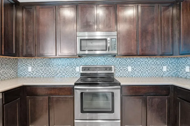 a kitchen with granite countertop wood cabinets and stainless steel appliances