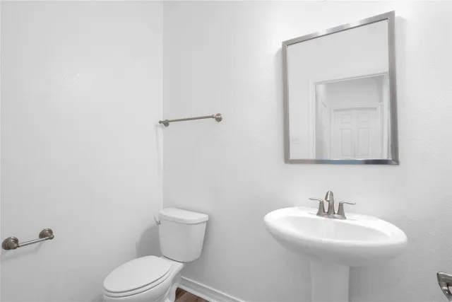 a bathroom with a sink toilet and mirror
