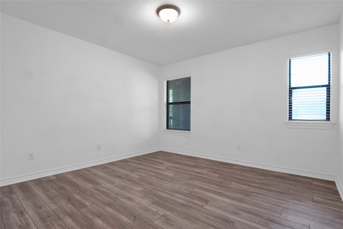 10217 English Oak Drive Austin, TX 78748 - Photo 25 of 31 an empty room with wooden floor and windows