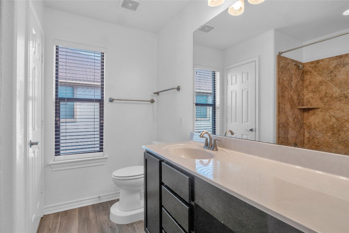 10217 English Oak Drive Austin, TX 78748 - Photo 28 of 31 a bathroom with a sink a toilet and a large mirror