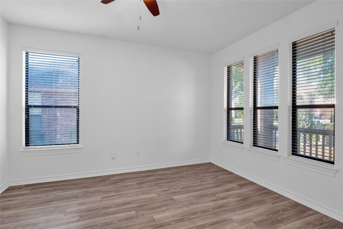 10217 English Oak Drive Austin, TX 78748 - Photo 6 of 31 an empty room with wooden floor and windows