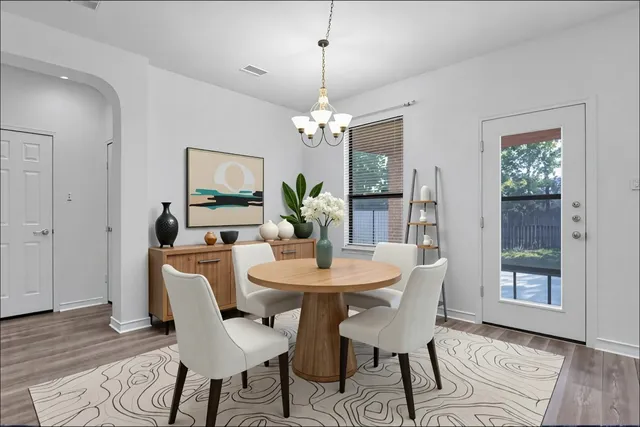 a dining room with furniture potted plants and wooden floor