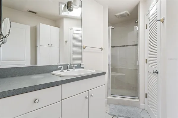 a bathroom with a granite countertop toilet sink and mirror