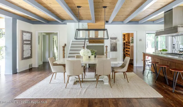 a kitchen with stainless steel appliances granite countertop a table chairs in it and wooden floors