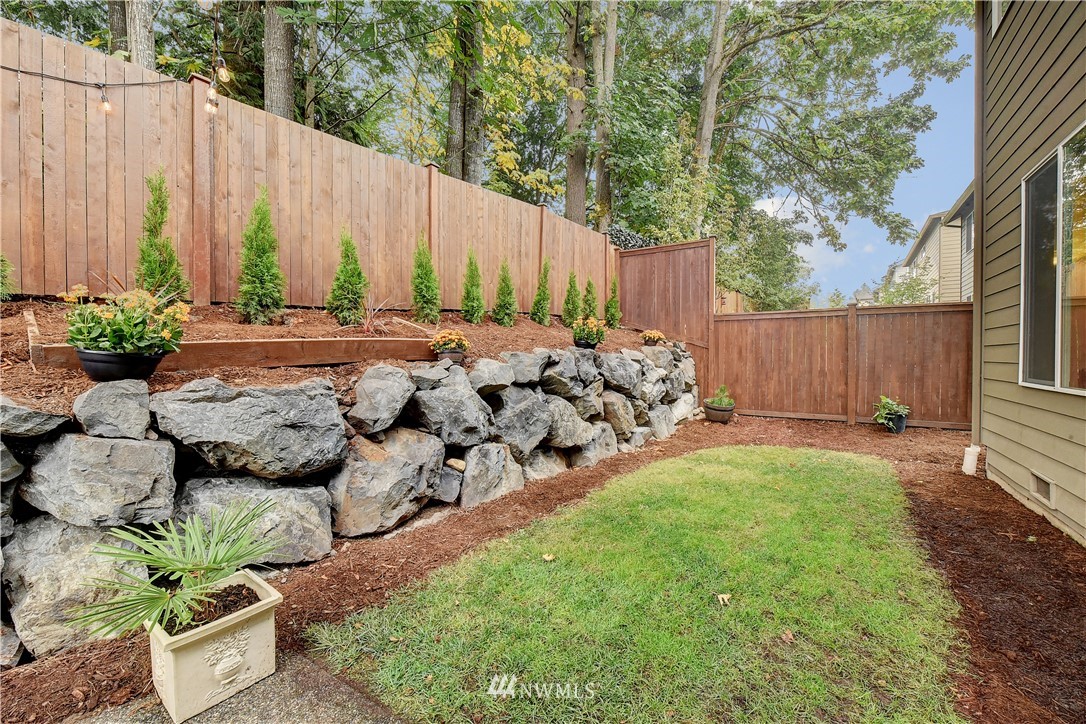 4321 229th Place Southeast Bothell, WA 98021 - Photo 30 of 31 a view of a backyard with chairs potted plants and wooden fence