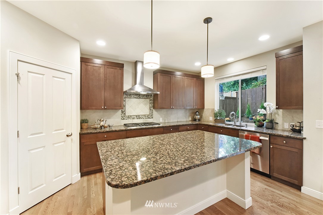4321 229th Place Southeast Bothell, WA 98021 - Photo 10 of 31 a view of a kitchen with kitchen island granite countertop a sink a counter space appliances and cabinets