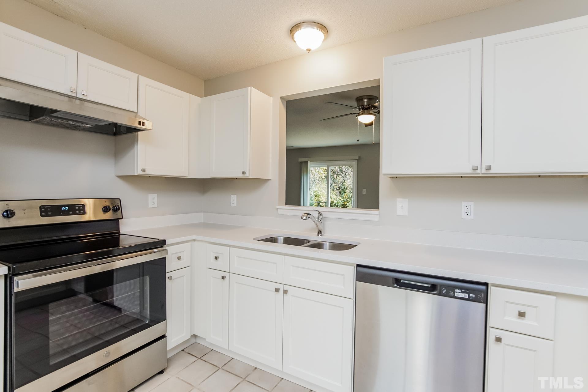 3901 Beaumont Court Raleigh, NC 27604 - Photo 8 of 16 a kitchen with white cabinets and appliances