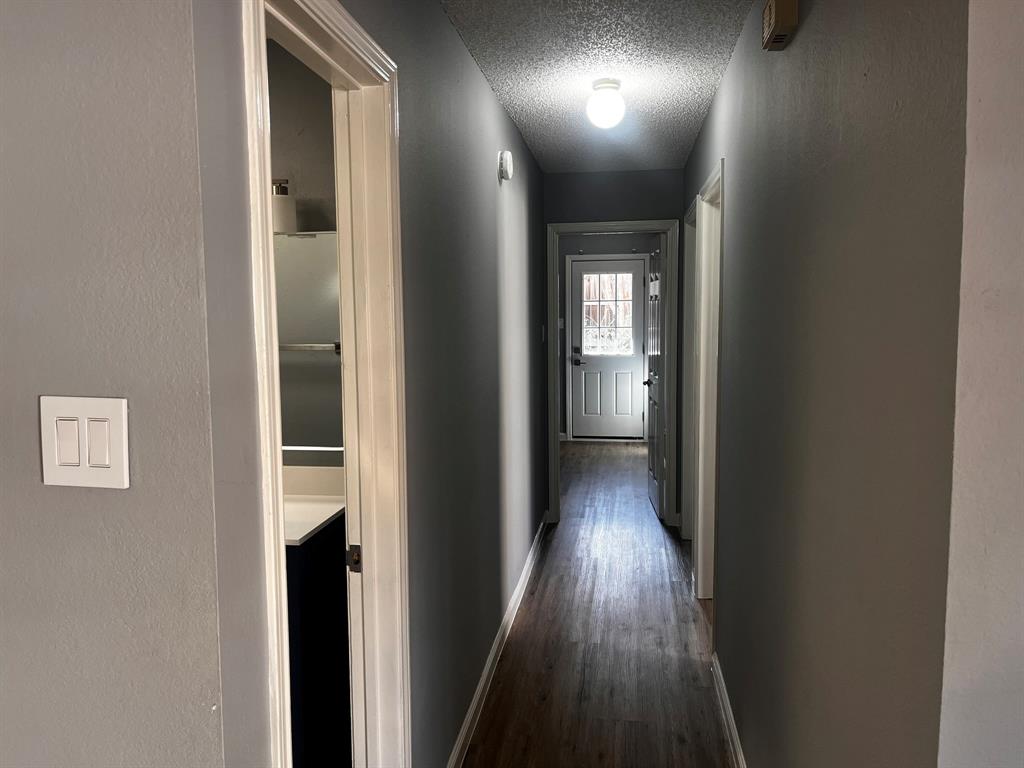 1007 Mack Place Denton, TX 76209 - Photo 15 of 37 Hall featuring a textured ceiling, a textured wall, and dark wood-style flooring