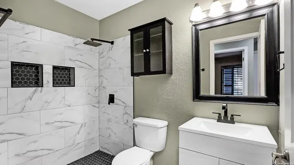 a bathroom with a toilet sink and mirror