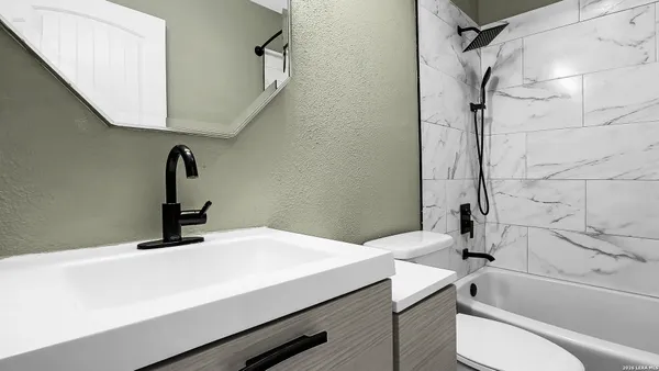 a bathroom with a sink a toilet and shower