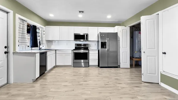 a kitchen with stainless steel appliances granite countertop a refrigerator sink and microwave
