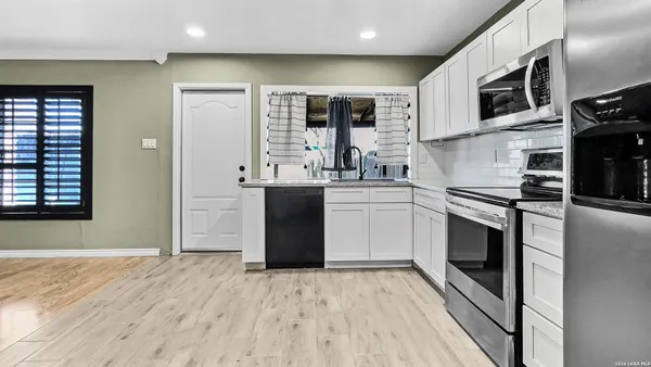 a kitchen with stainless steel appliances granite countertop a stove sink and cabinets
