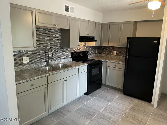 a kitchen with stainless steel appliances granite countertop a refrigerator stove and sink
