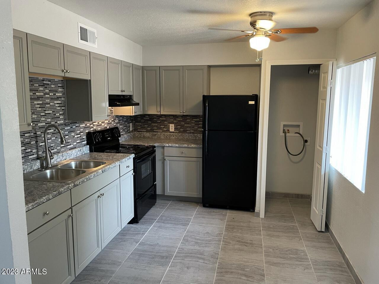 1222 East Mountain View Road, Unit 114 208 214 Phoenix, AZ 85020 - Photo 5 of 21 a kitchen with a refrigerator and a sink