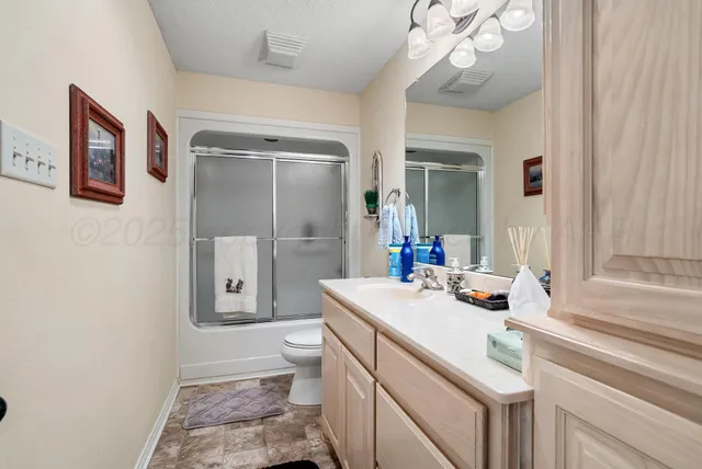 a bathroom with a sink a toilet and a large mirror