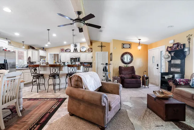 a living room with lots of furniture and view of kitchen