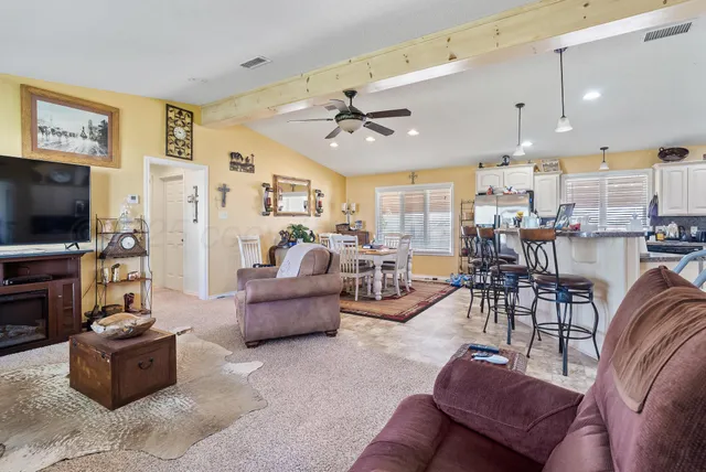 a living room with furniture kitchen view and a flat screen tv