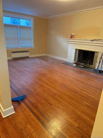 an empty room with wooden floor and a window