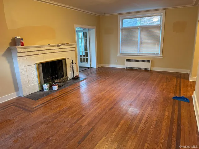 a view of a livingroom with wooden floor and a fireplace
