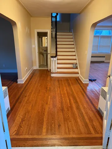 a view of a livingroom with wooden floor and stairs
