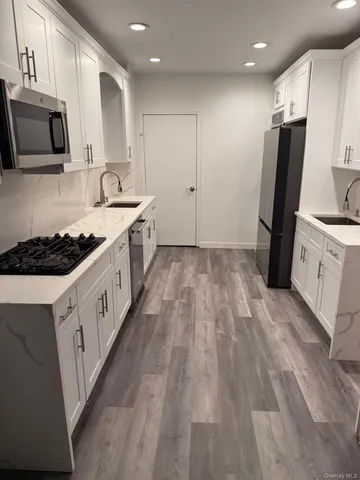 a large kitchen with stainless steel appliances granite countertop a stove a sink and a refrigerator