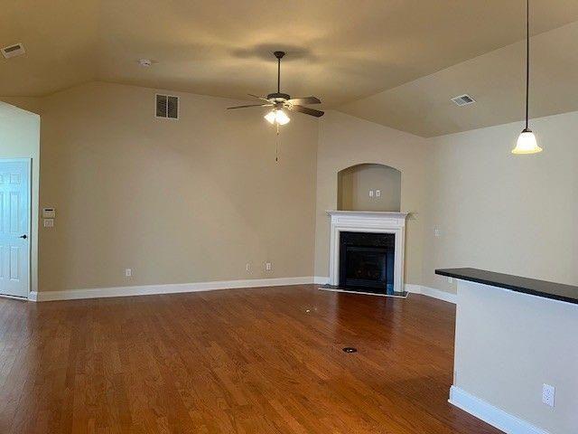 238 Abercorn Way Woodstock, GA 30188 - Photo 9 of 27 an empty room with wooden floor fireplace chandelier and windows