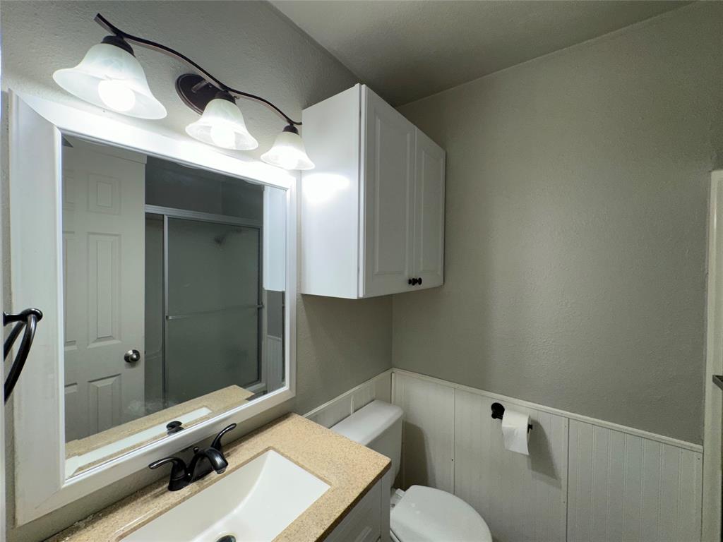 2004 Throckmorton Street Gainesville, TX 76240 - Photo 14 of 24 a bathroom with a sink and mirror