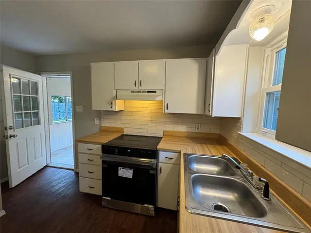 a kitchen with granite countertop a sink and a stove top oven