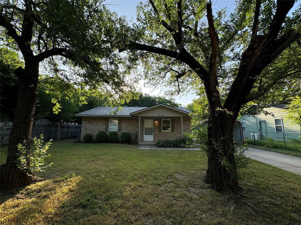 2004 Throckmorton Street Gainesville, TX 76240 - Photo 2 of 24 a yellow house in middle of the forest