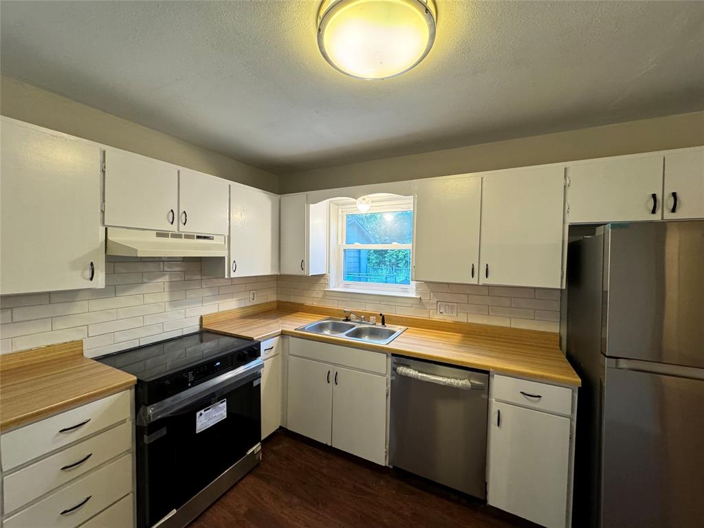 2004 Throckmorton Street Gainesville, TX 76240 - Photo 22 of 24 a kitchen with a white cabinets and white appliances
