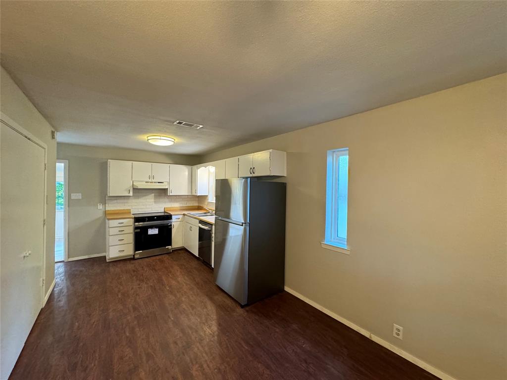 2004 Throckmorton Street Gainesville, TX 76240 - Photo 23 of 24 a view of kitchen with refrigerator and wooden floor