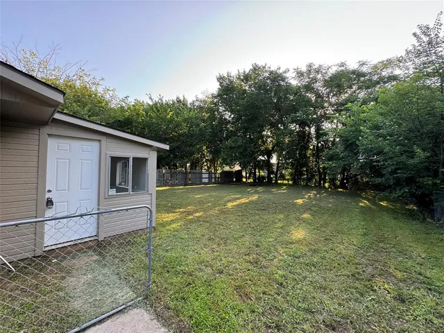 a view of backyard of house with trees
