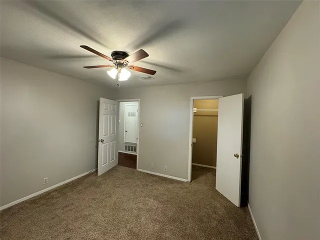 an empty room and chandelier fan
