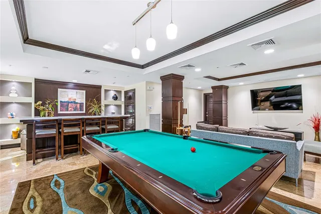 a room with pool table flat screen tv and windows