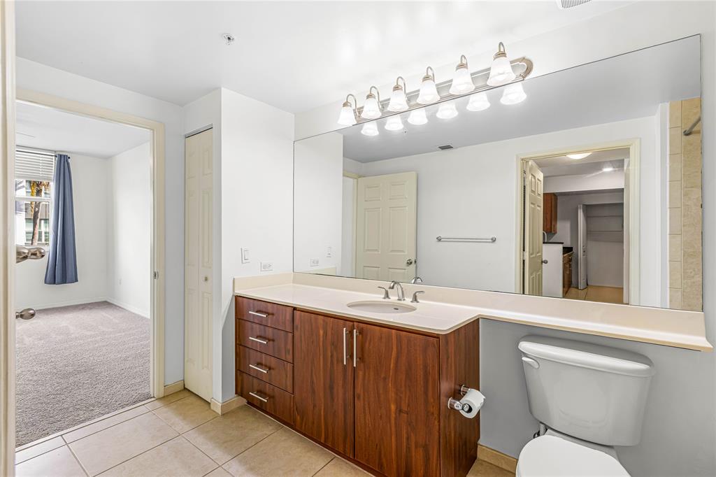 2421 Northeast 65th Street, Unit 318 Fort Lauderdale, FL 33308 - Photo 8 of 31 a bathroom with a toilet sink and mirror