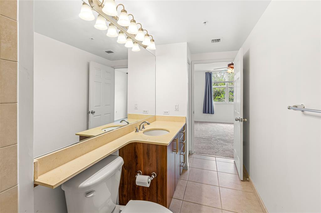 2421 Northeast 65th Street, Unit 318 Fort Lauderdale, FL 33308 - Photo 9 of 31 a bathroom with a sink a vanity and mirror