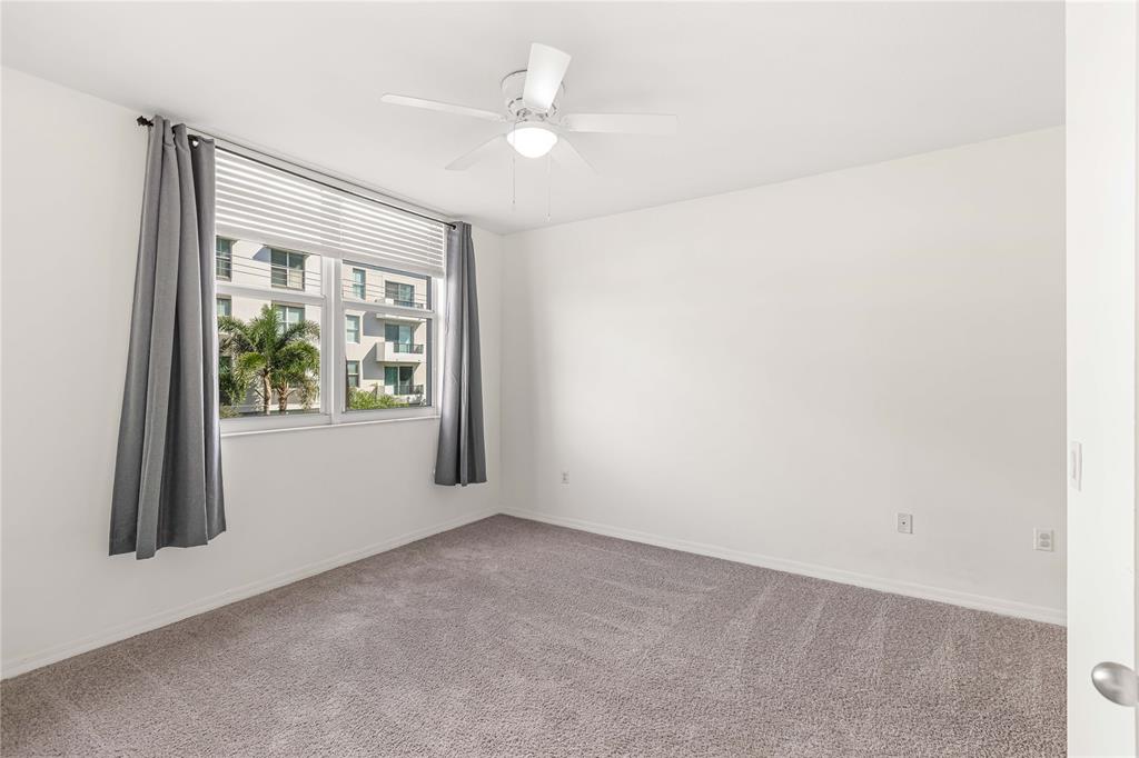 2421 Northeast 65th Street, Unit 318 Fort Lauderdale, FL 33308 - Photo 10 of 31 an empty room with windows and closet