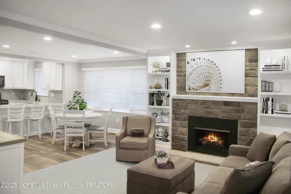 a living room with furniture a fireplace and a kitchen view