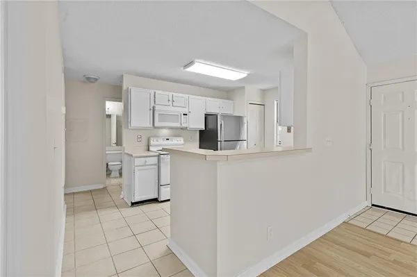 a kitchen with white cabinets and white appliances